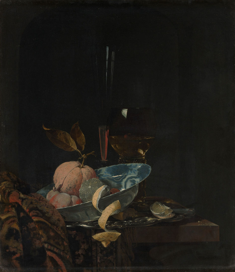 A lemon peel spills out from a blue bowl onto a table decorated with fabric.