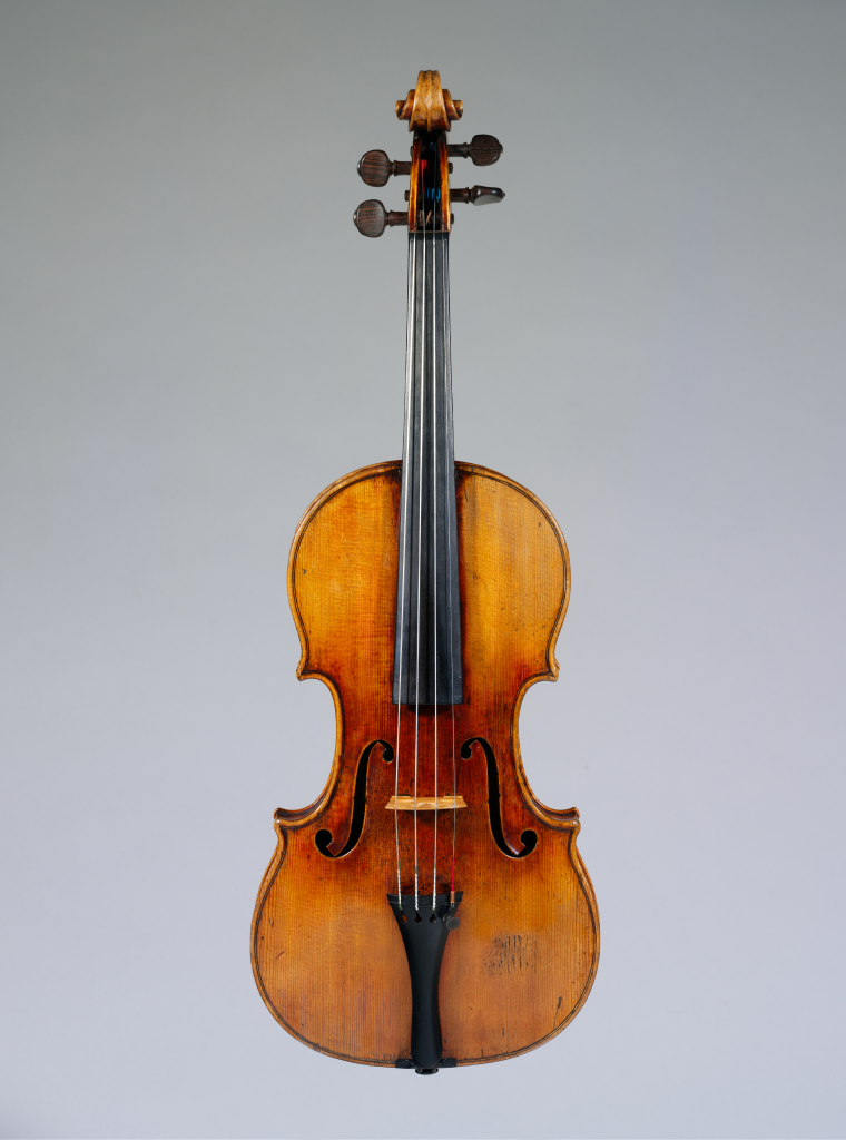 Warm-hued violin in front of a gray backdrop