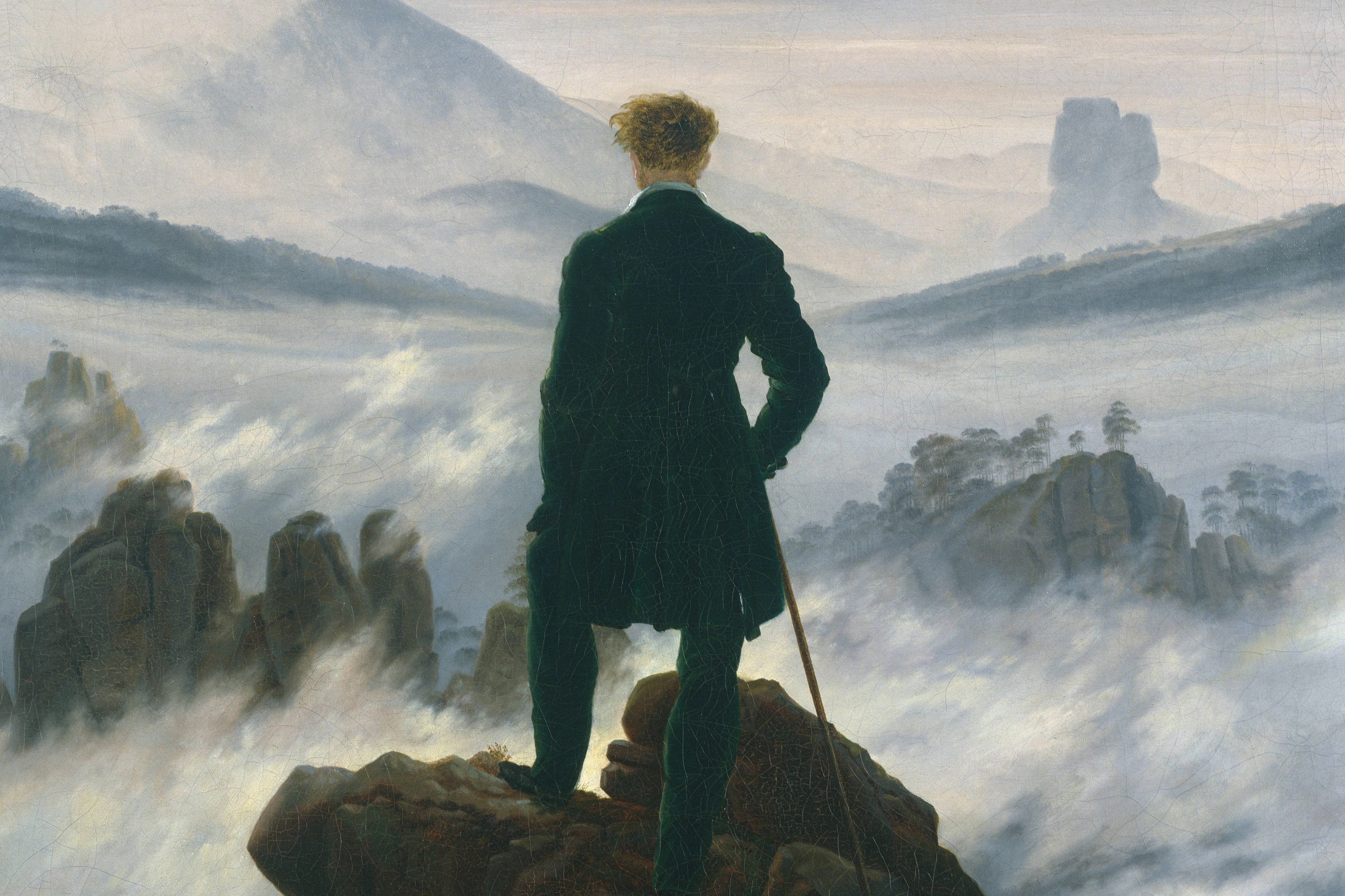 A painting in grey tones of the back of a man looking out over the hillside covered in mist.