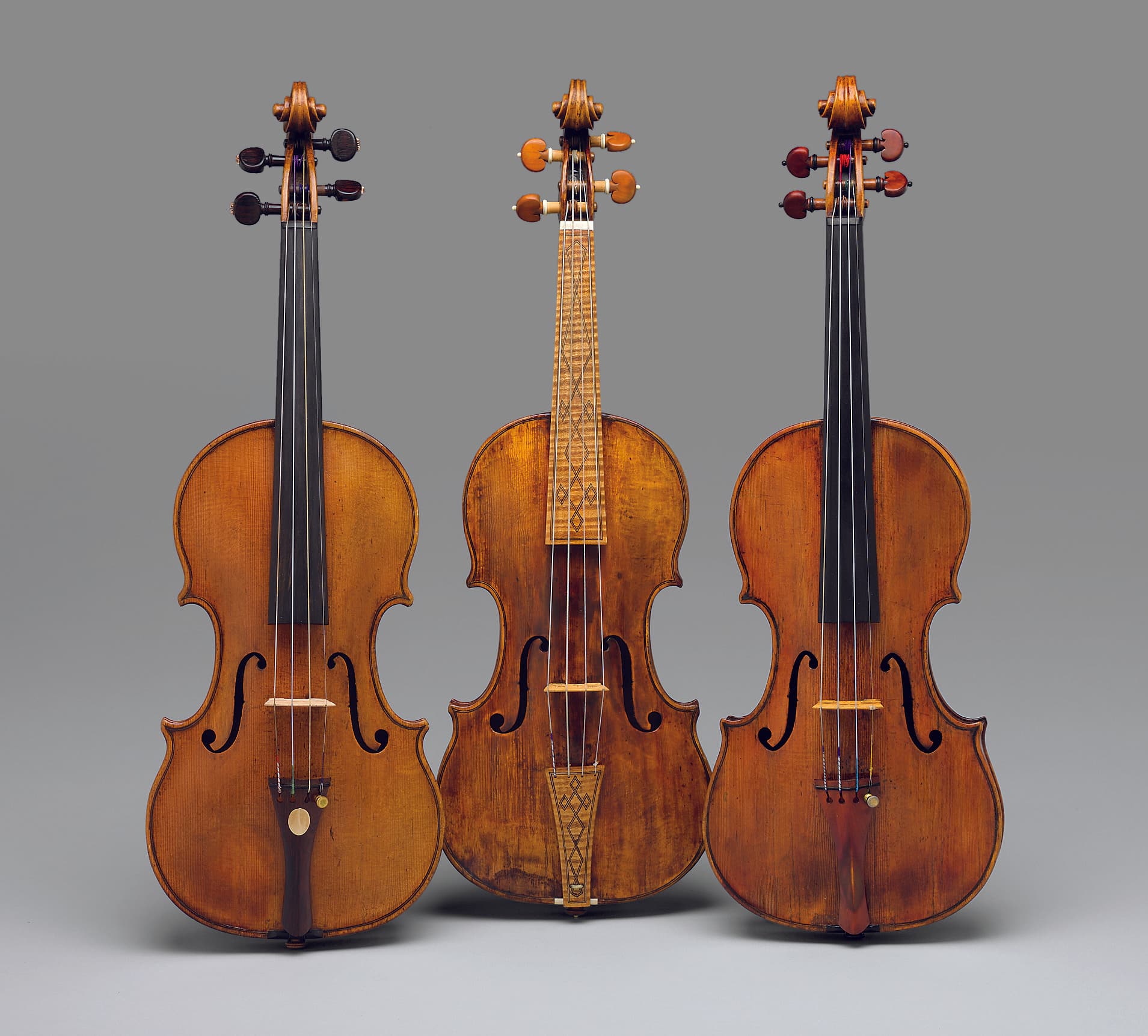 Three violins in both Baroque and Classical set ups placed side by side.
