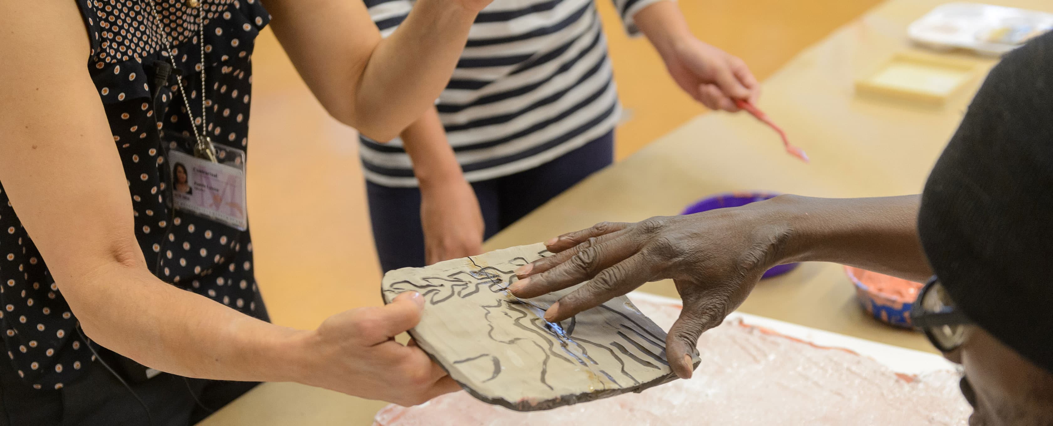 A man who is blind or partially sighted feels the texture of an etched object.