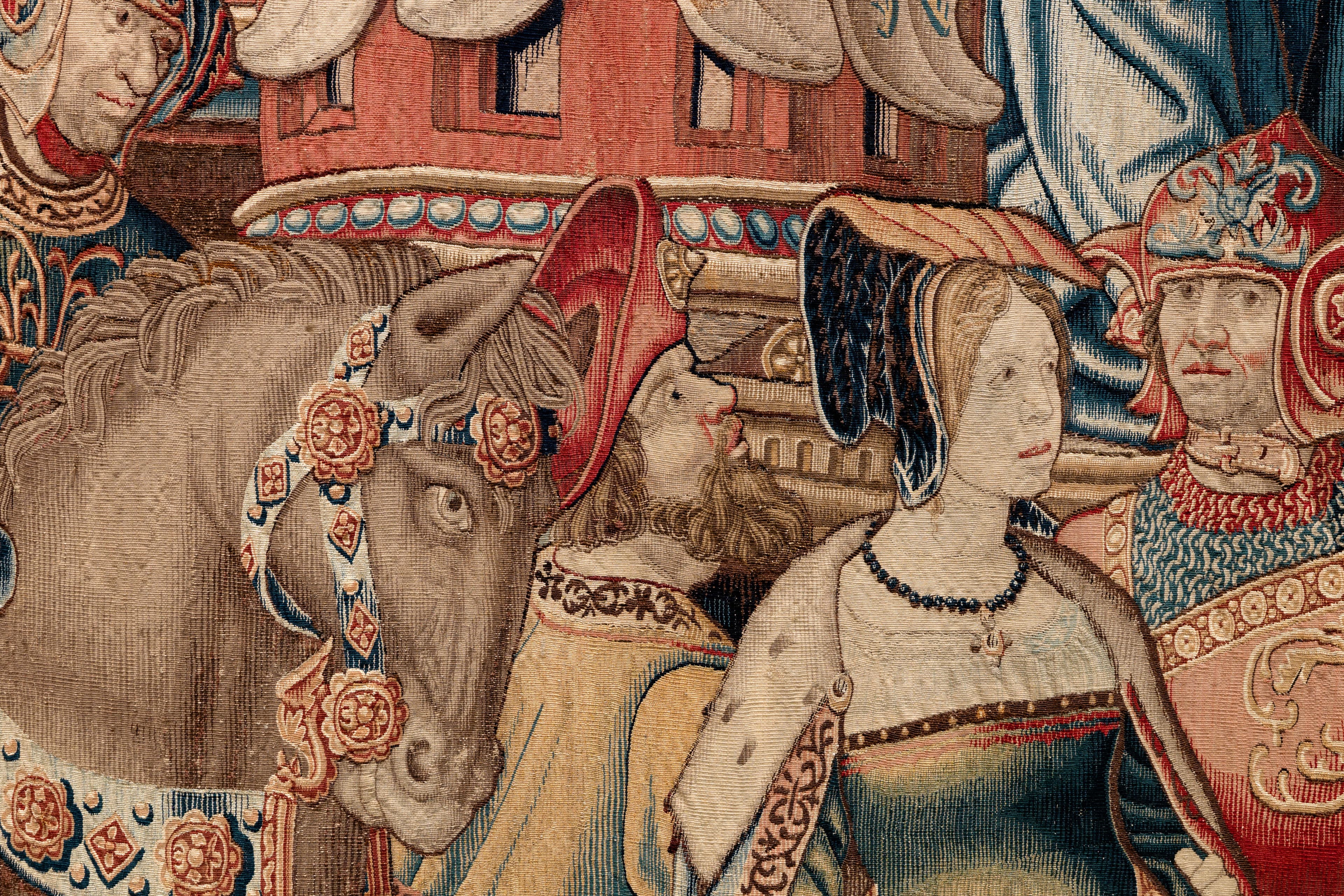 A detail shot of a tapestry, showing a man on a horse, a bearded man looking up, a woman wearing a folded headpiece, and a man in uniform.