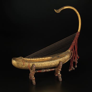 Photo of golden Burmese Harp against dark background