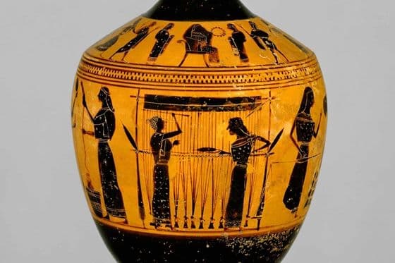 Terracotta lekythos, or oil flask, with black figures of women weaving on a loom on orange ground.