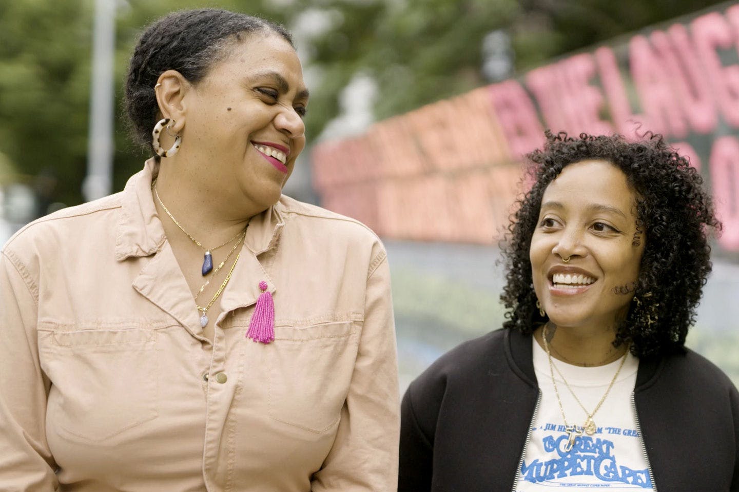 Mildred Beltré and Oasa DuVerney smile during their interview about Brooklyn Hi-Art! Machine's family portraits project.