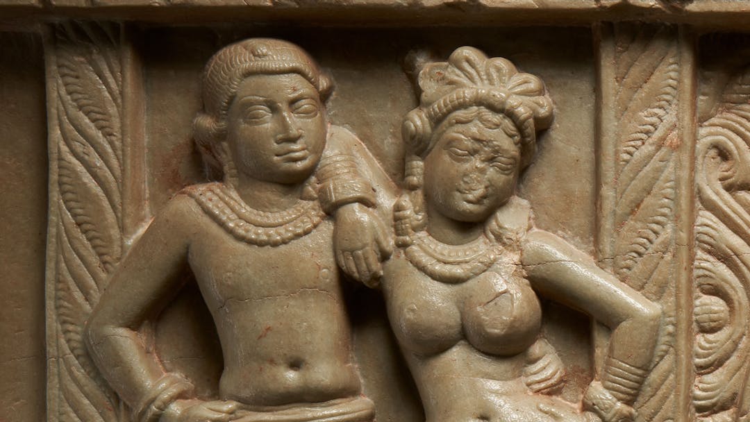 Limestone carving of a male and female figure