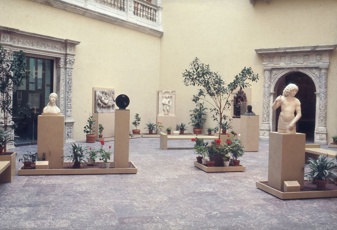 An interior courtyard featuring sculptures and potted plants