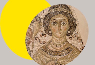 Brown and beige fragment of a floor mosaic with a brown-skinned woman with curly brown hair, a headpiece, and earrings set against a bright yellow ovular spotlight shape in the background.