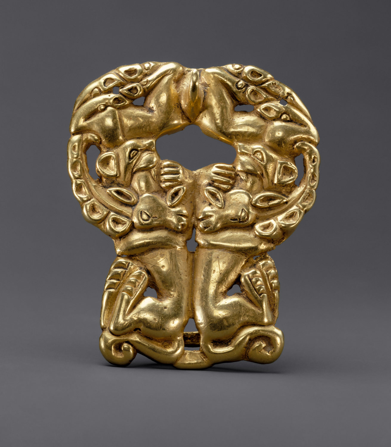 Belt buckle: paired felines attacking ibexes