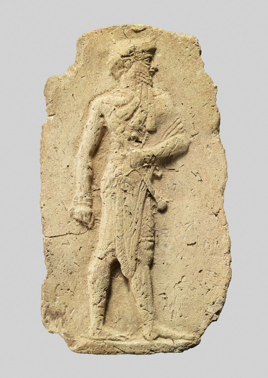 Molded plaque: king or a god carrying a mace