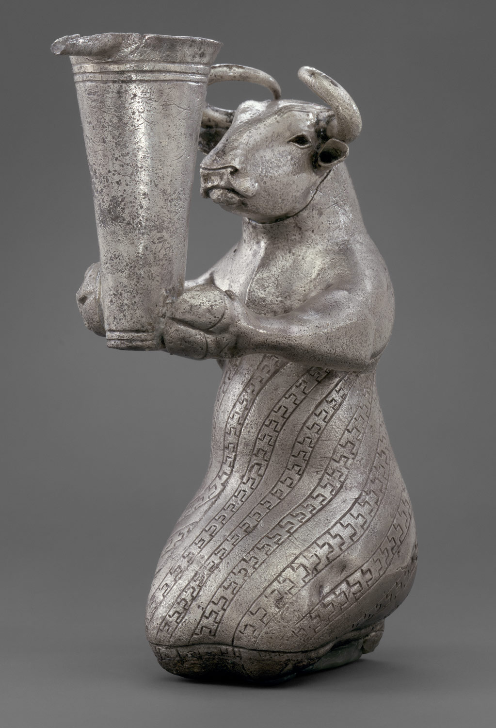 Kneeling bull holding a spouted vessel