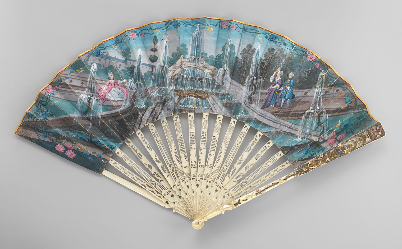 An image of a decorative French folding fan with vibrant figures and a water fountain done in Rococo style. 